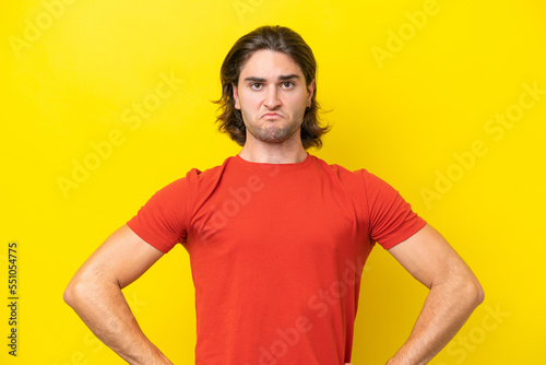 Caucasian handsome man isolated on yellow background angry