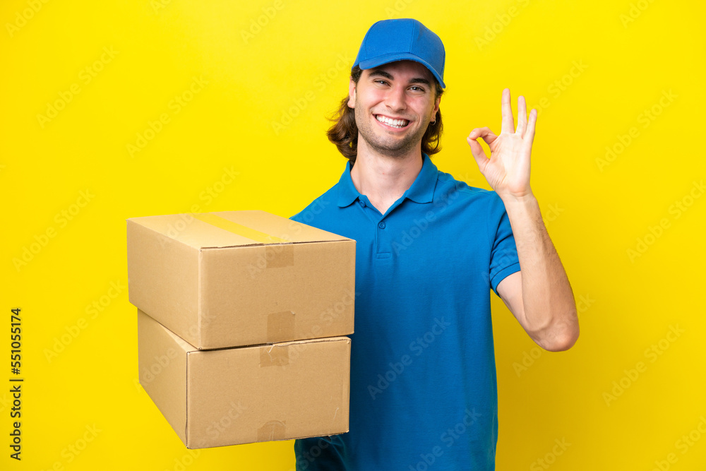 Delivery handsome man isolated on yellow background showing ok sign with fingers Delivery handsome man isolated on yellow background showing ok sign with fingers
