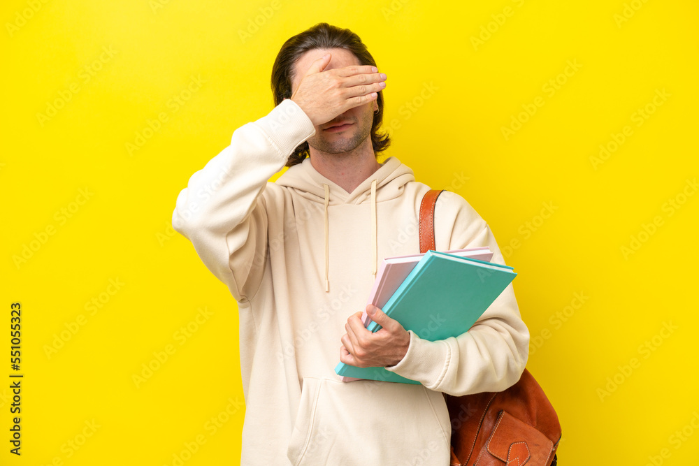 Young student handsome man isolated on yellow background covering eyes by hands. Do not want to see something Young student handsome man isolated on yellow background covering eyes by hands. Do not want to see something