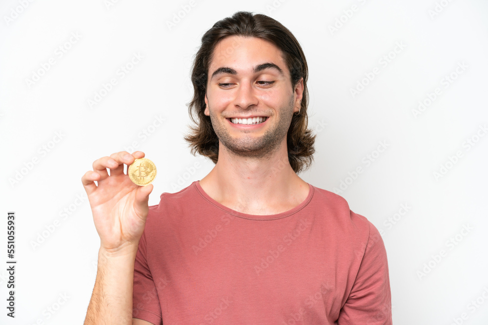 Young handsome man holding a Bitcoin isolated on white background with happy expression Young handsome man holding a Bitcoin isolated on white background with happy expression