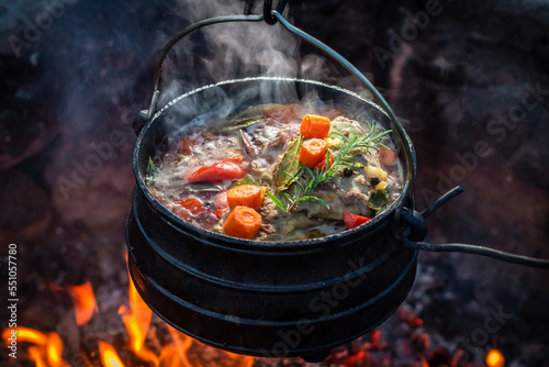 Delicious and hot hunter's stew on bonfire.