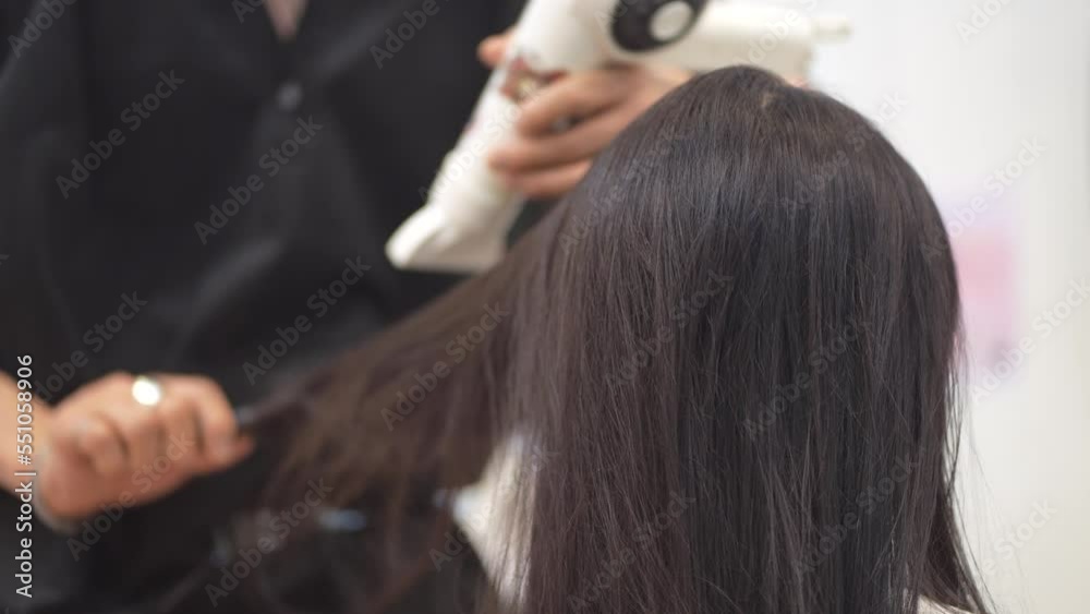 ドライヤーで女性の髪を乾かす男性美容師 ドライヤーで女性の髪を乾かす男性美容師