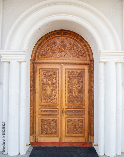 A carved wooden door at the Orthodox church in Reghin city - Romania It is handmade with floral and religious motifs