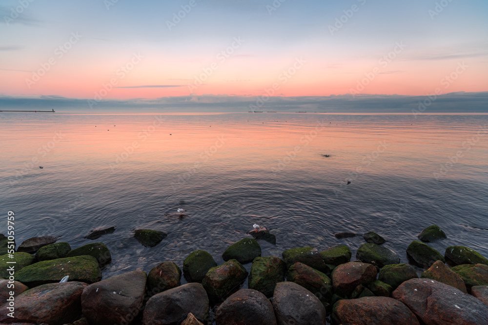 the setting sun in Gdynia behind the sea horizon
