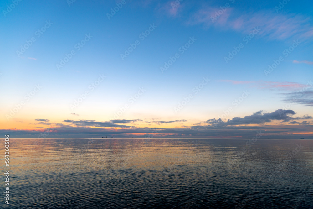 the setting sun in Gdynia behind the sea horizon