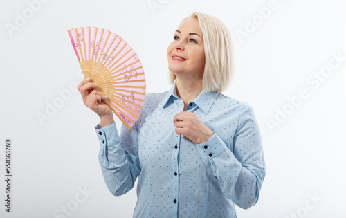 Beautiful middle aged woman with menopause blowing by fan. Hormone replacement therapy and mature woman healthcare. Mid age happy women lifestyle. Senior woman isolated on white. photo