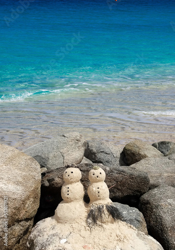 Sandy snowmen on the beach photo