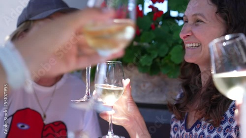 Happy family and friends clinking glasses. Authentic people toasting with white wine