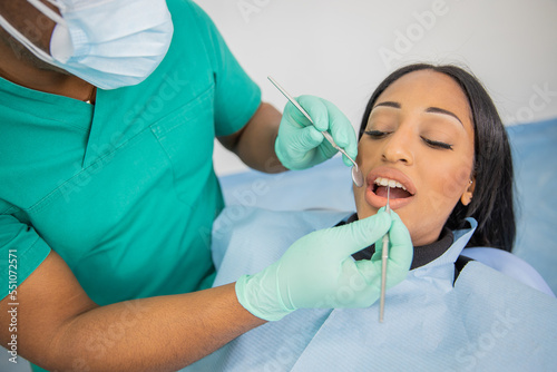 Girl during a dental visit  doctor with dental tools examines her mouth.