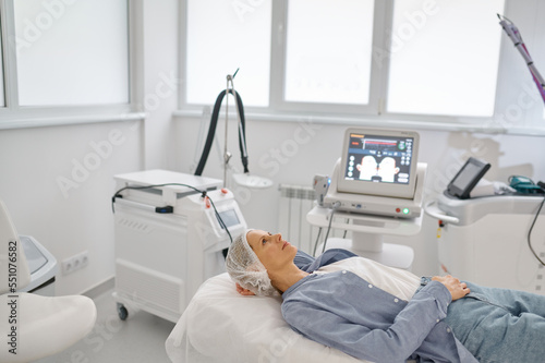 Woman lying on couch waiting for procedure at cosmetologist office