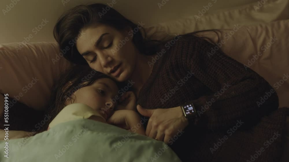 Close up of mother comforting daughter in bed / South Jordan, Utah, United States Close up of mother comforting daughter in bed / South Jordan, Utah, United States