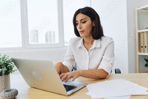 Woman business works at her laptop at home in her office, freelance employee in business