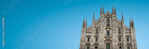 Banner with magnificent Cathedral of Milano at blue sky gradient background with copy space, Milan, Italy. Concept of historical and religious heritage sites conservation