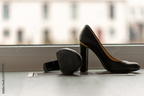 Black high heel pumps in front of a window and on a light floor