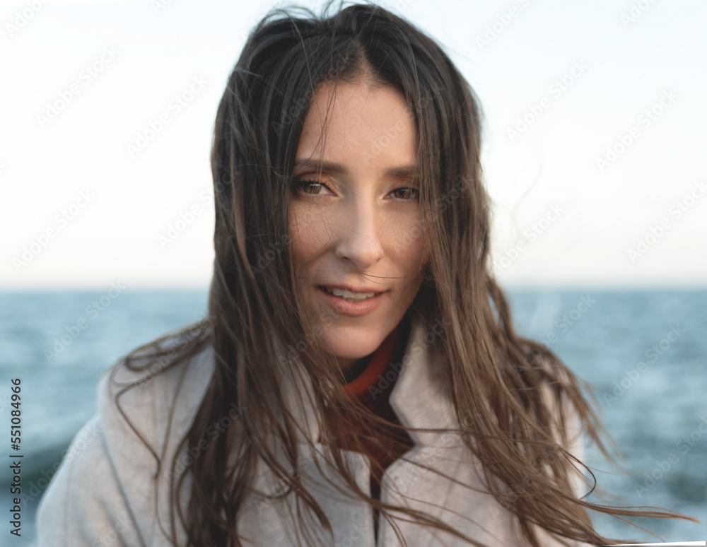 portrait of a tender and sensitive woman on the background of the sea. Hair development in the wind