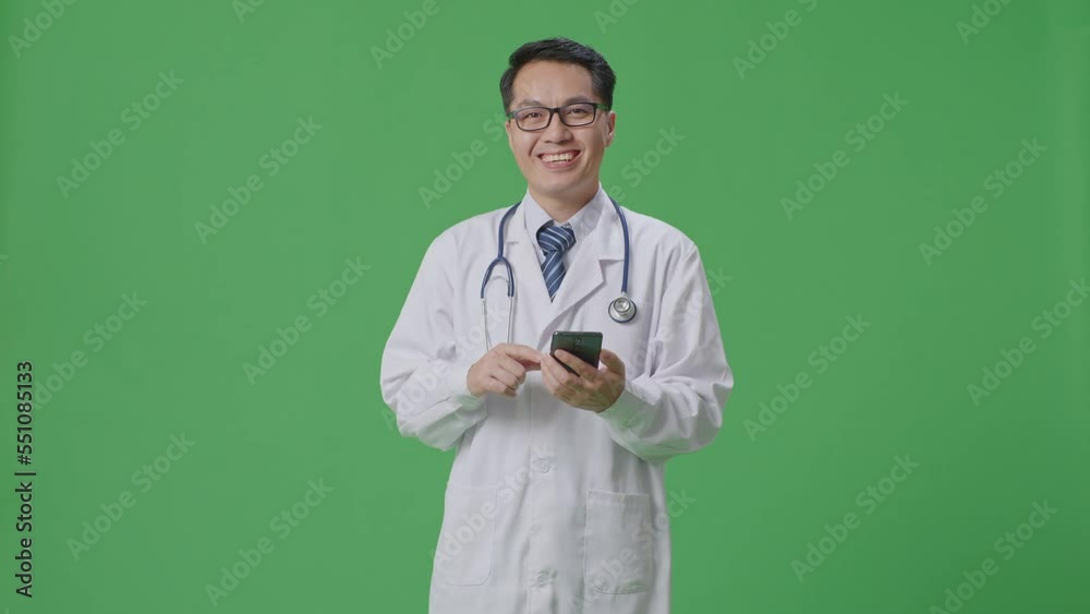 Asian Male Doctor With Stethoscope Using Smartphone And Smiling While Standing On Green Screen Background In The Hospital
Asian Male Doctor With Stethoscope Using Smartphone And Smiling While Standing On Green Screen Background In The Hospital
