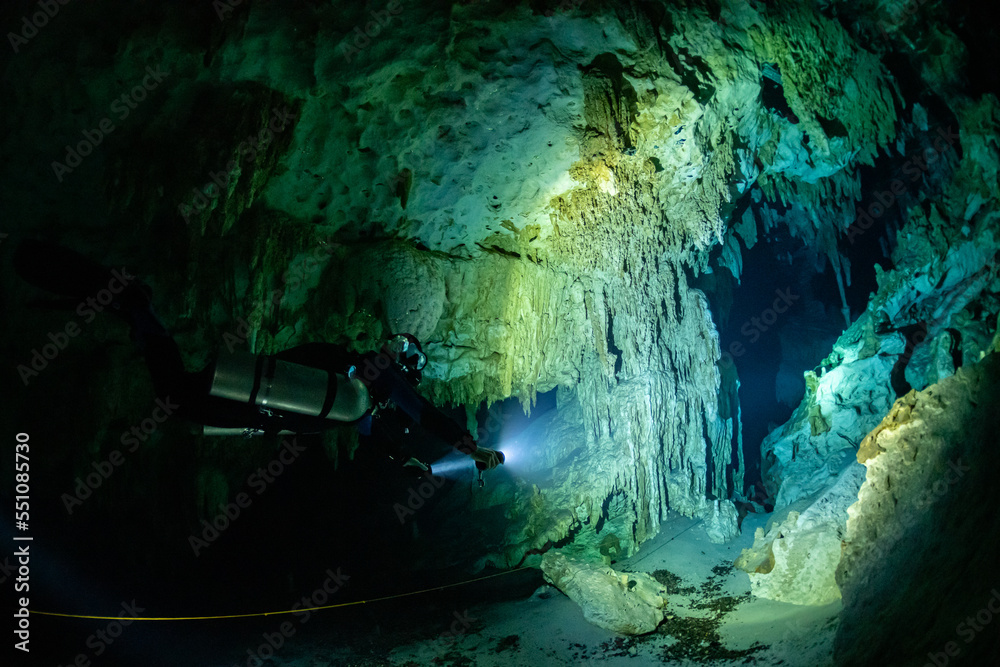 cave diver instructor leading a group of divers in a mexican cenote underwater cave diver instructor leading a group of divers in a mexican cenote underwater