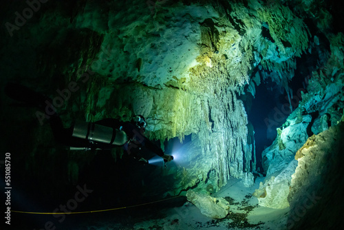 cave diver instructor leading a group of divers in a mexican cenote underwater