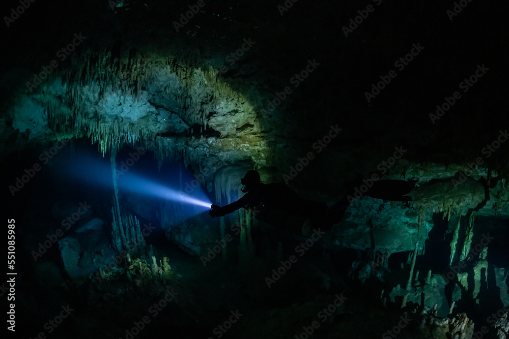 Fototapeta premium cave diver instructor leading a group of divers in a mexican cenote underwater