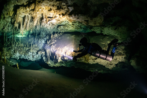Fotografie cave diver instructor leading a group of divers in a mexican cenote underwater
