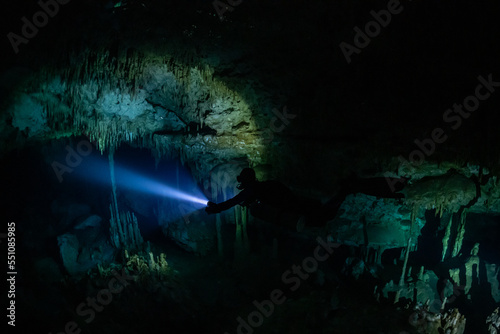 cave diver instructor leading a group of divers in a mexican cenote underwater