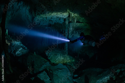 cave diver instructor leading a group of divers in a mexican cenote underwater