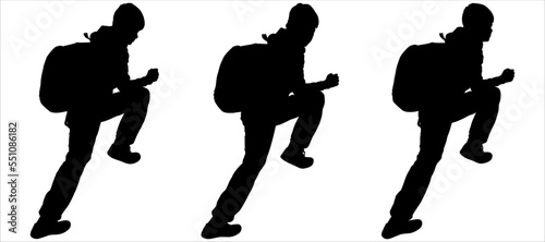 The teen climbs the slope. The traveler goes to the mountains with a backpack. A boy with a backpack behind his back, raised one leg high, makes a rise. Side view. Black silhouette isolated on white