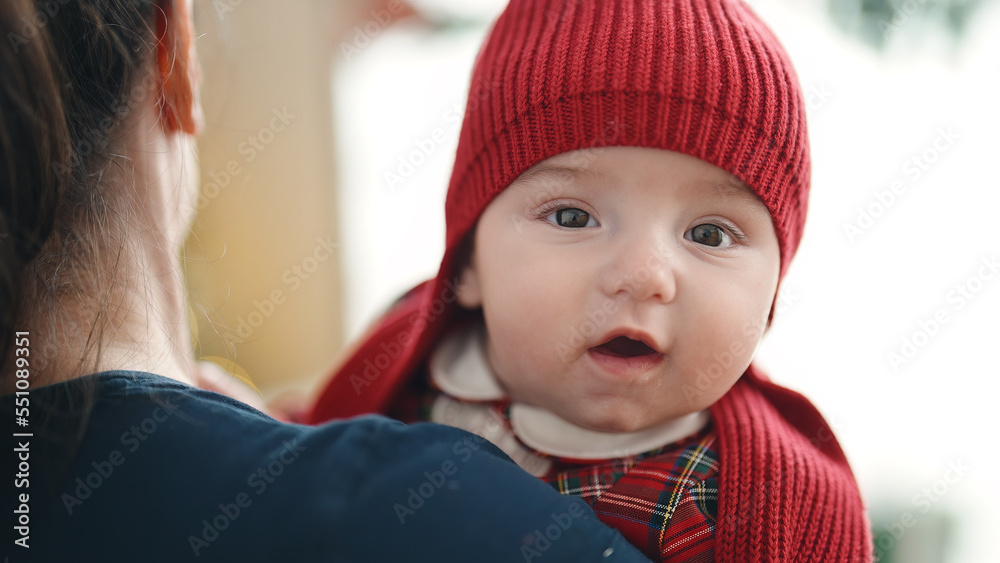 Adorable caucasian baby relaxed on mother arms at home Adorable caucasian baby relaxed on mother arms at home