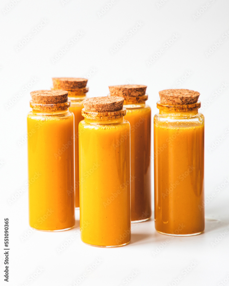 Homemade Immune Boosting Turmeric Ginger Citrus Shots. Anti-Inflammatory Vitamin Rich Healthy Drink. White background, free space. Immunity System Booster Homemade Immune Boosting Turmeric Ginger Citrus Shots. Anti-Inflammatory Vitamin Rich Healthy Drink. White background, free space. Immunity System Booster