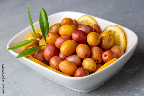 Scratched green olives. Tasty organic green olives in the plate. Olive on marble floor. Turkish name; cizik zeytin photo