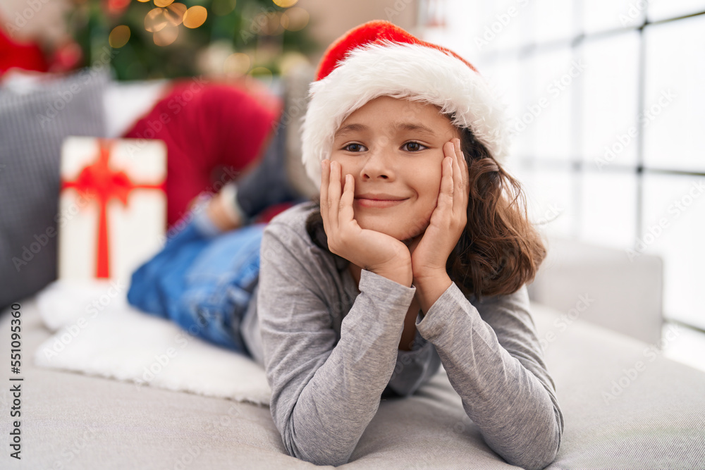 Adorable chinese girl smiling confident lying on sofa by christmas tree at home Adorable chinese girl smiling confident lying on sofa by christmas tree at home