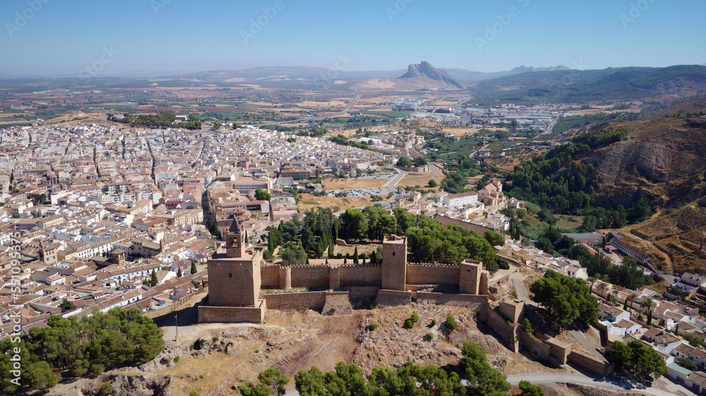 Aerial drone view of Antequera castle with the natural monument The Lovers Rock in the background. Touristic travel to Spain. Historic interest and Unesco World Heritage Site. 
