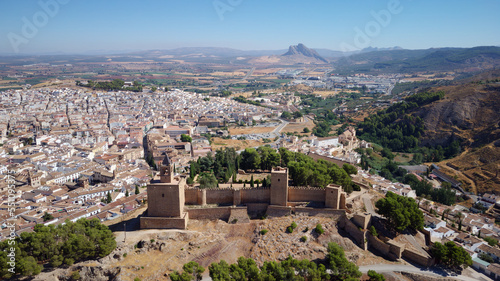 Aerial drone view of Antequera castle with the natural monument The Lovers Rock in the background. Touristic travel to Spain. Historic interest and Unesco World Heritage Site. 