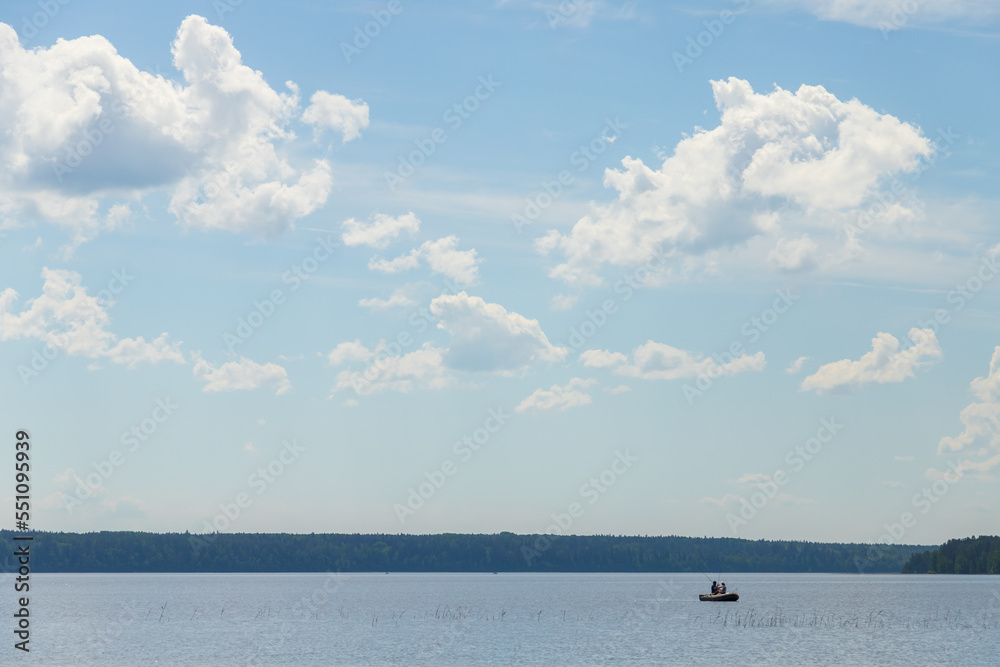 Landscape photo with fishermen in a boat on a summer sunny day