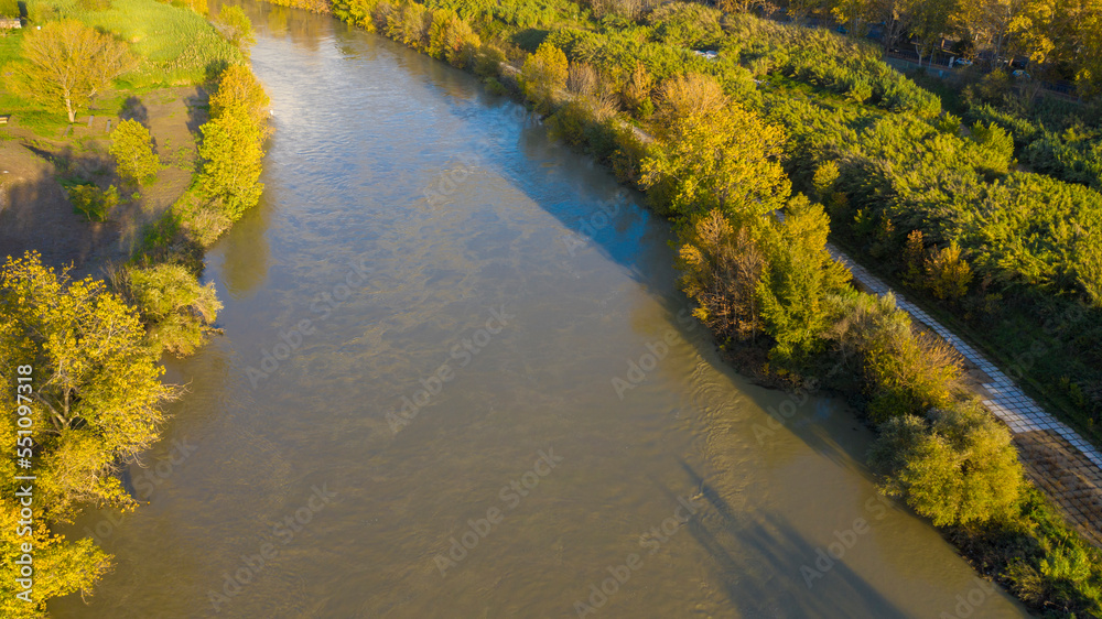 Aerial view over the Tiber River near Marconi district in Rome, Italy. Autumn colors dye the trees along the river.