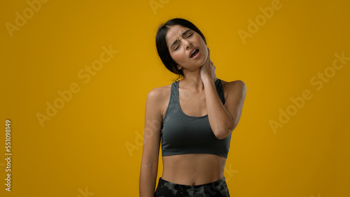 Sad sick ill unhappy Indian sporty woman sports lady athlete sport girl has neck pain problem with posture injury ache discomfort bad feeling muscle sore trauma unhealthy spine after fitness workout