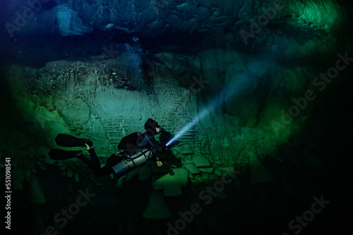 cave diver instructor leading a group of divers in a mexican cenote underwater