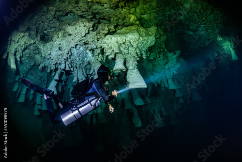 cave diver instructor leading a group of divers in a mexican cenote underwater