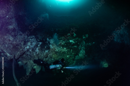 Fotografie cave diver instructor leading a group of divers in a mexican cenote underwater