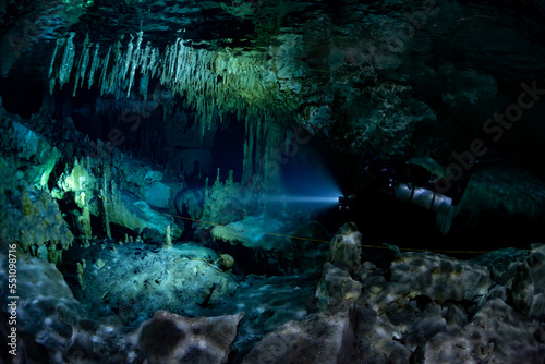 cave diver instructor leading a group of divers in a mexican cenote underwater