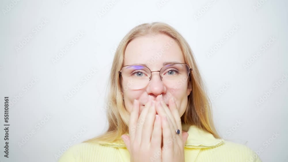 Shocked surprised cute young blonde european woman holding cheeks by hands with astonished expression expressing excitement and joy. Girl in glasses and yellow sweater. White studio background stock Shocked surprised cute young blonde european woman holding cheeks by hands with astonished expression expressing excitement and joy. Girl in glasses and yellow sweater. White studio background stock