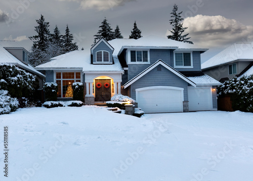 Residential home decorated for Christmas and New Year holidays with fresh blanket of snow