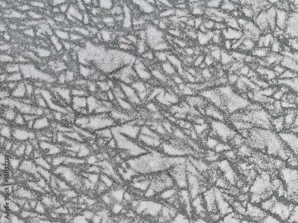 Ice dusted with snow close up. Textured natural background in gray and white colors. 
