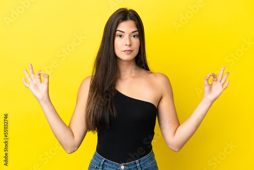 Young Brazilian woman isolated on yellow background in zen pose