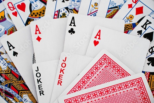 Playing cards background with spread out cards.  Decorative diamond, hearts, spades, clubs, jokers, aces, card mix.