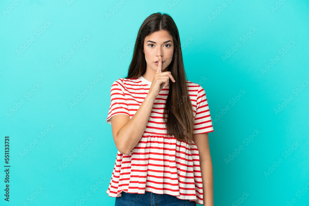 Young Brazilian woman isolated on blue background showing a sign of silence gesture putting finger in mouth Young Brazilian woman isolated on blue background showing a sign of silence gesture putting finger in mouth