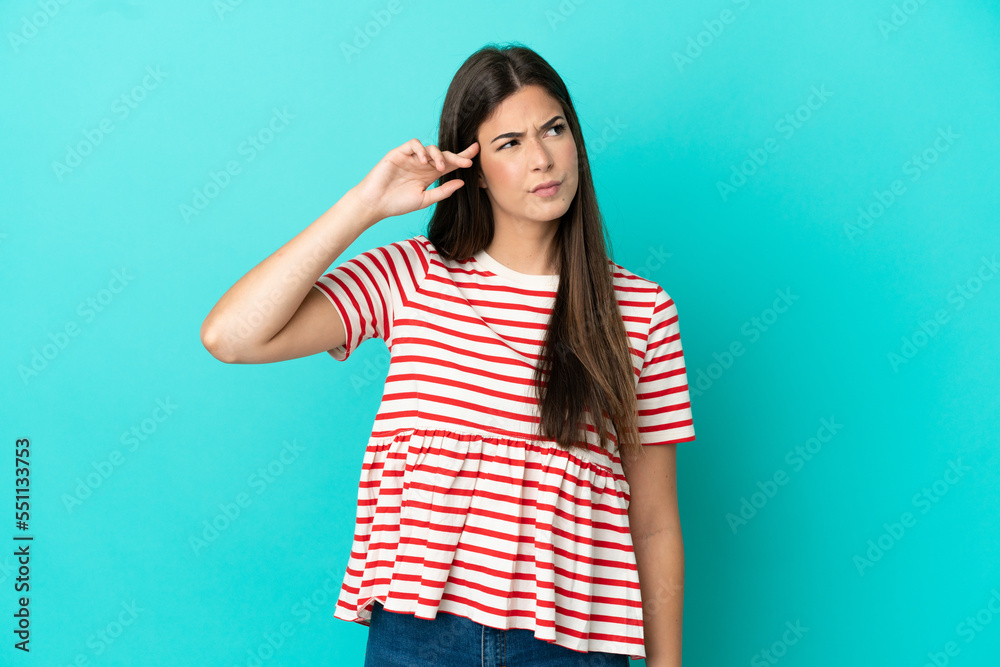 Young Brazilian woman isolated on blue background making the gesture of madness putting finger on the head Young Brazilian woman isolated on blue background making the gesture of madness putting finger on the head
