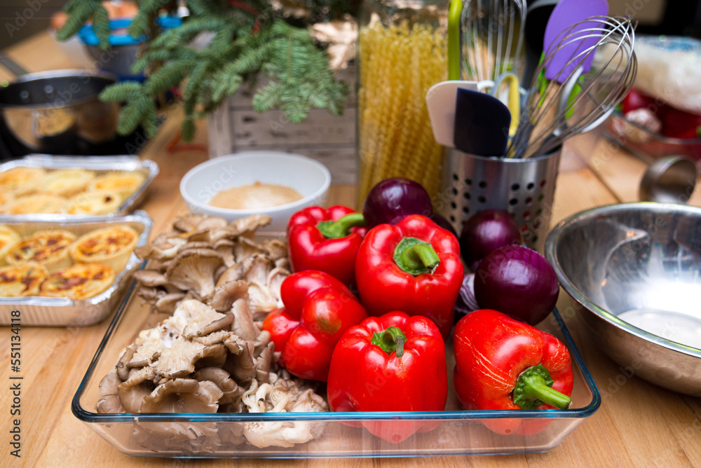 Set of raw red onions, red bell peppers, fresh oyster mushrooms in a glass dish. Kitchen table before cooking.