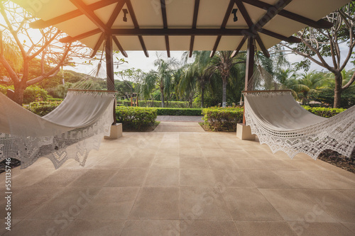 Two hammocks hang under roof photo