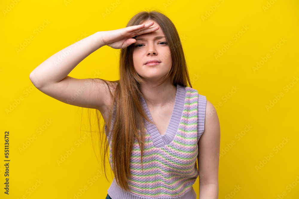 Fototapeta premium Young caucasian woman isolated on yellow background looking far away with hand to look something